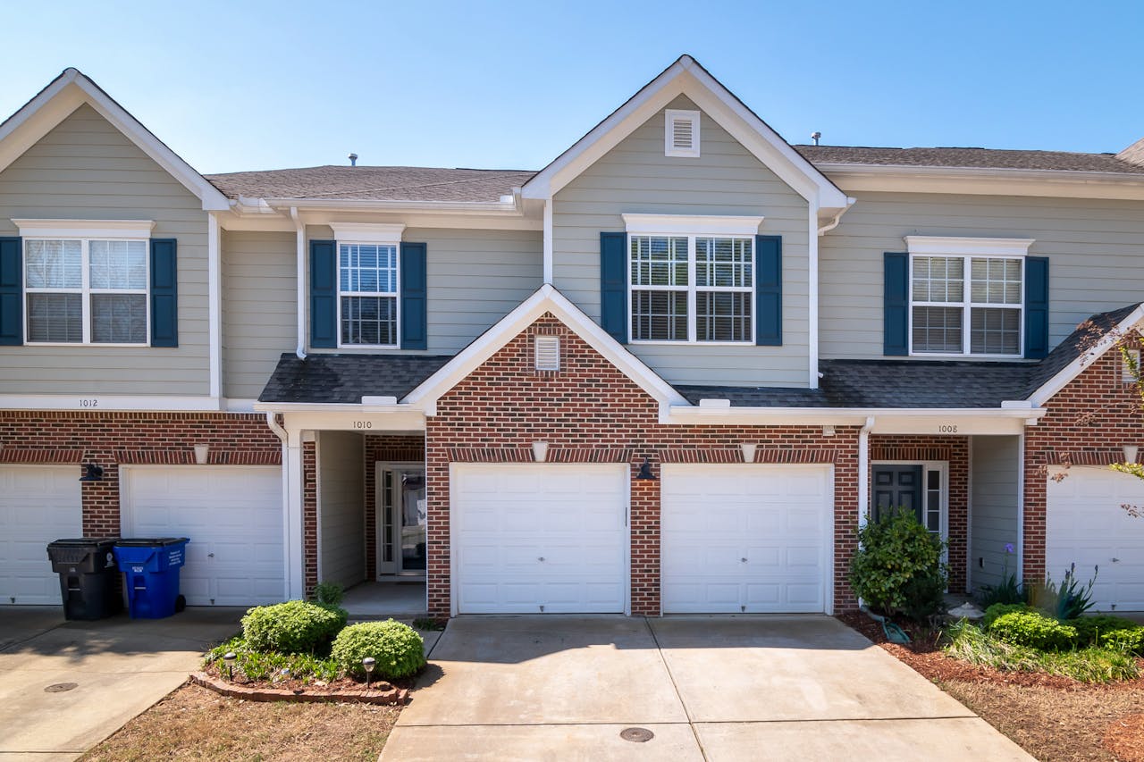Modern suburban townhouses with garages in a quiet residential neighborhood.